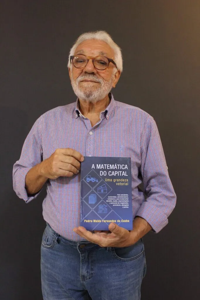 Professor Pedro-Waldo segurando o livro A Matemática do Capital